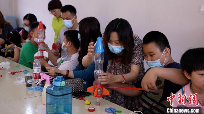 学生们在老师指导下制作水火箭。 王鑫铭 摄 学生们在老师指导下制作水火箭。 王鑫铭 摄